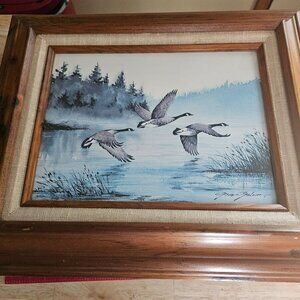 beautiful frame painting signed by the artist gene Graham titled ducks in flight